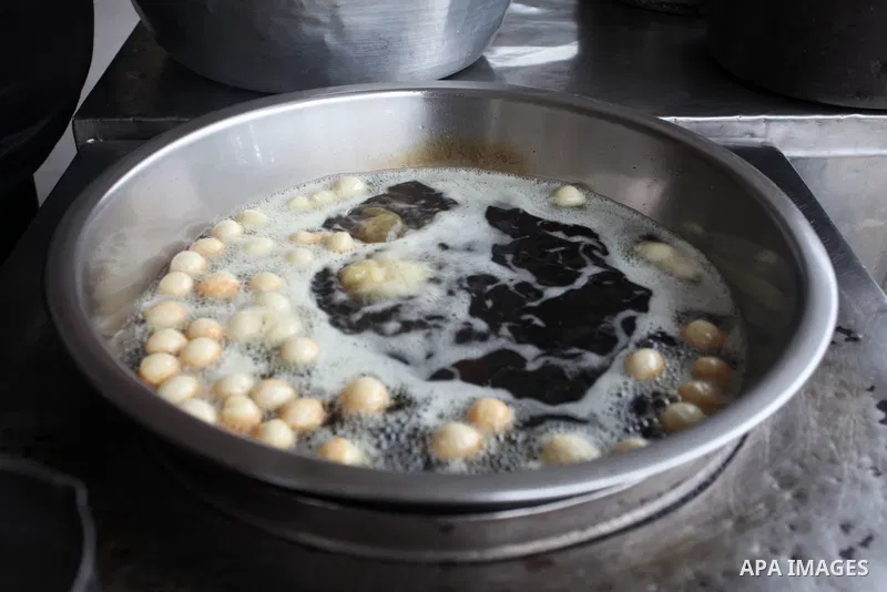Palestinian vendor prepares traditional sweet called "awwamah" during winter, at Al Shati refugee camp, in Gaza city on December 9, 2021. Awwamah is a traditional sweet, Gazans eat it on winter. Weather today is partly c...