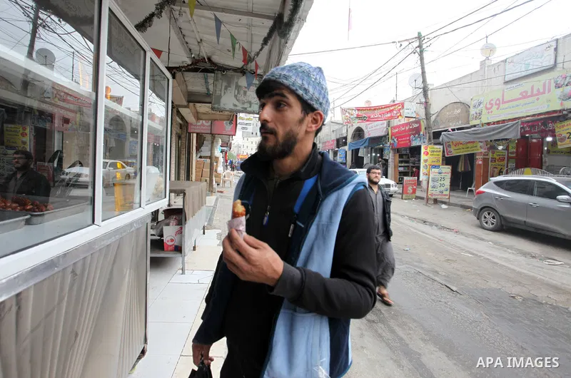 Palestinian vendor prepares traditional sweet called "awwamah" during winter, at Al Shati refugee camp, in Gaza city on December 9, 2021. Awwamah is a traditional sweet, Gazans eat it on winter. Weather today is partly c...
