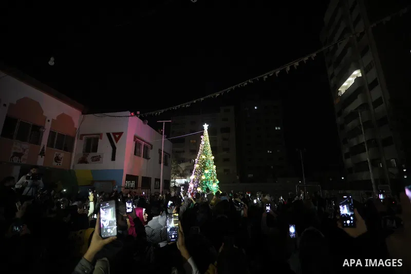 Palestinians gather to celebrate the lighting of the Christmas tree in Gaza city on December 10, 2021. Photo by Ashraf Amra