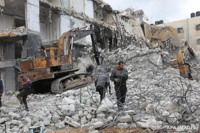 Palestinian workers remove the rubbles of al-Jawhara tower which was hit by Israeli strikes during the recent 11-day conflict between Israel and Hamas on May, on December 22, 2021. Photo by Ashraf Amra