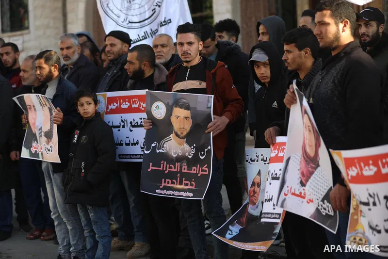 Palestinians hold placards during a protest in solidarity with female prisoners at Israeli jails, in Deir Al Balah in the center of Gaza strip on December 21, 2021. Photo by Ashraf Amra