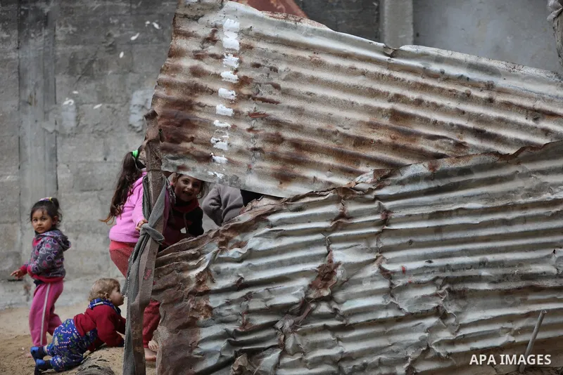 Palestinian children play outside their home on a cold, rainy day in Beit Lahia in the northern Gaza Strip December 23, 2021. Photo by Ashraf Amra