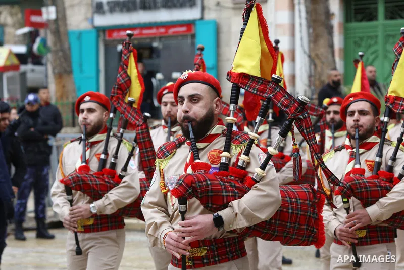 Palestinian scouts parade outside the Church of the Nativity, revered as the site of Jesus Christ's birth, during Christmas celebrations in the biblical city of Bethlehem in the West Bank, on December 24, 2021. Photo by...