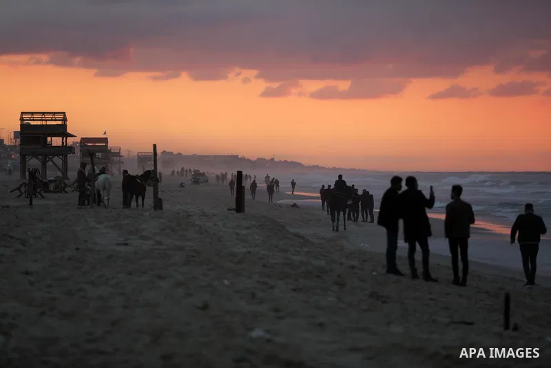 Palestinians enjoy their time on the beach of Gaza sea during sunset on December 24, 2021. The beach is one of the few open public spaces in this densely populated city. Photo by Ashraf Amra