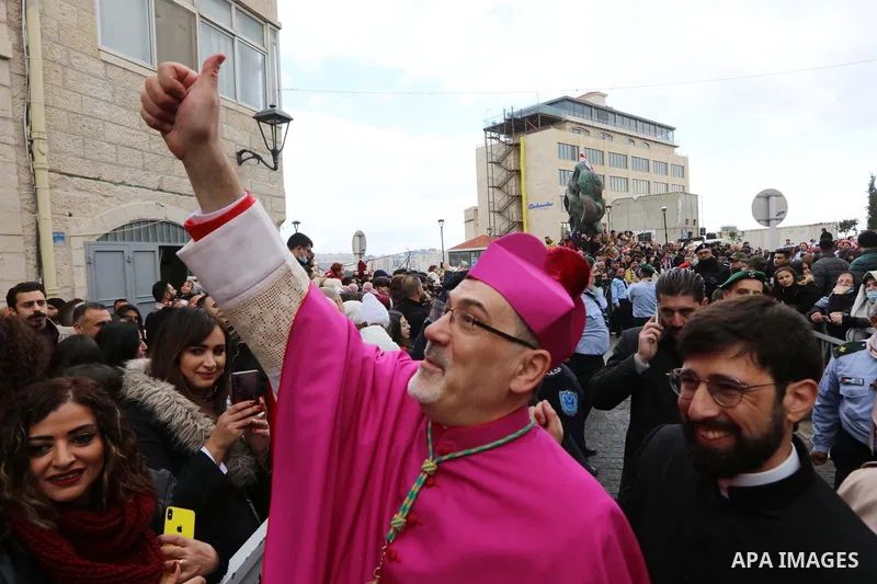 Pierbattista Pizzaballa, the Latin Patriarch of Jerusalem, greets people as he arrives to attend Christmas celebrations in Bethlehem, in the West Bank on December 24, 2021. Photo by Ahmad Tayem