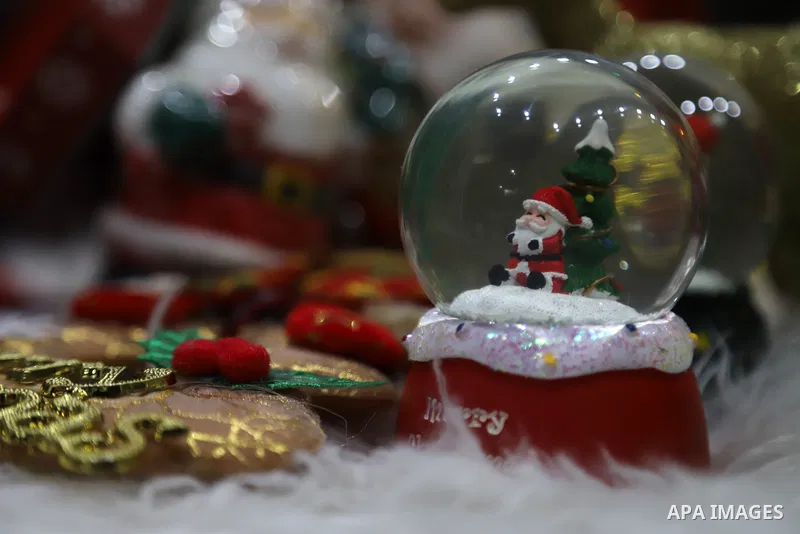 Palestinian girl Doaa Magdi hangs Christmas decoration during Christmas celebrations, at her shop in Gaza city on December 26, 2021. Christmas is an annual festival commemorating the birth of Jesus Christ. Photo by Omar...