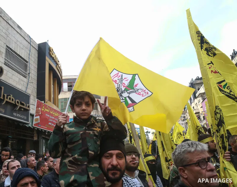 Palestinian supporters of the Fatah movement take part during a rally marking the 57th anniversary of the creation of the political party, in the West Bank city of Ramallah, on December 30, 2021. Photo by Ahmad Arouri