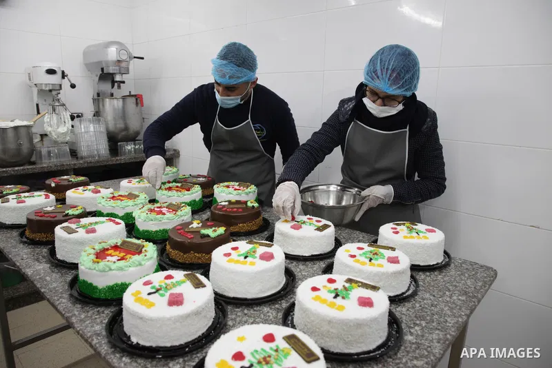 Palestinian chefs put final touches on cakes which portrays the new year number "2022", in Gaza city 30, 2021. Gazans hope for peace, prosperity in 2022 after the recent 11-day conflict between Israel and Hamas on May. P...