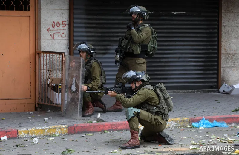 Palestinian protesters clash with Israeli troops in the West Bank city of Hebron, following a protest in solidarity with Palestinian prisoners held in Israeli jails, on December 31, 2021. Photo by Mamoun Wazwaz