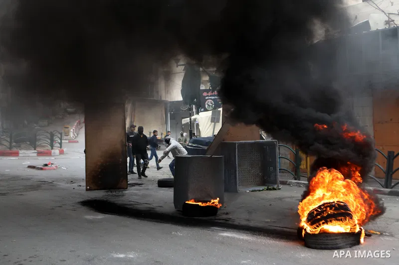 Palestinian protesters clash with Israeli troops in the West Bank city of Hebron, following a protest in solidarity with Palestinian prisoners held in Israeli jails, on December 31, 2021. Photo by Mamoun Wazwaz