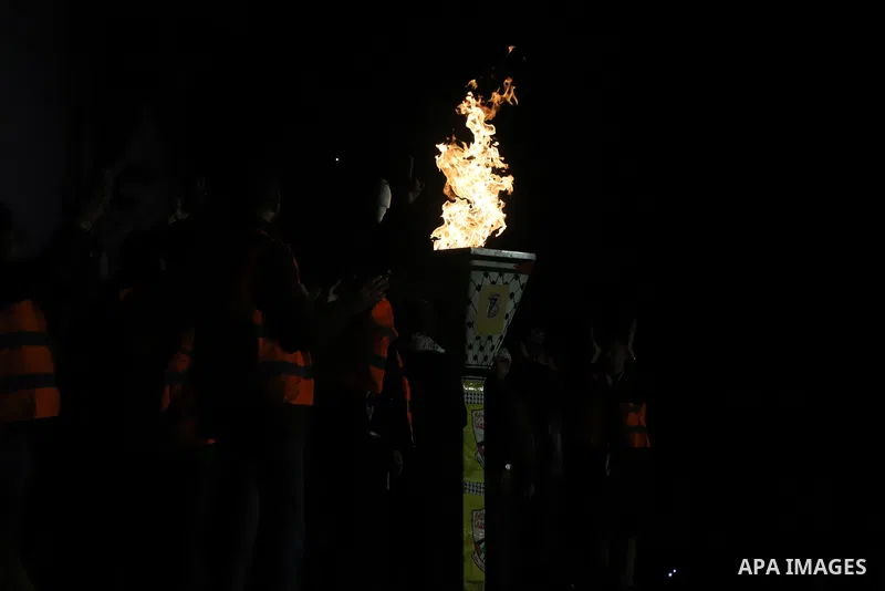 Palestinians light a torch during a celebration marking the 57th anniversary of Fatah movement foundation, in Gaza city on Decemeber 31, 2021. Photo by Omar Ashtawy