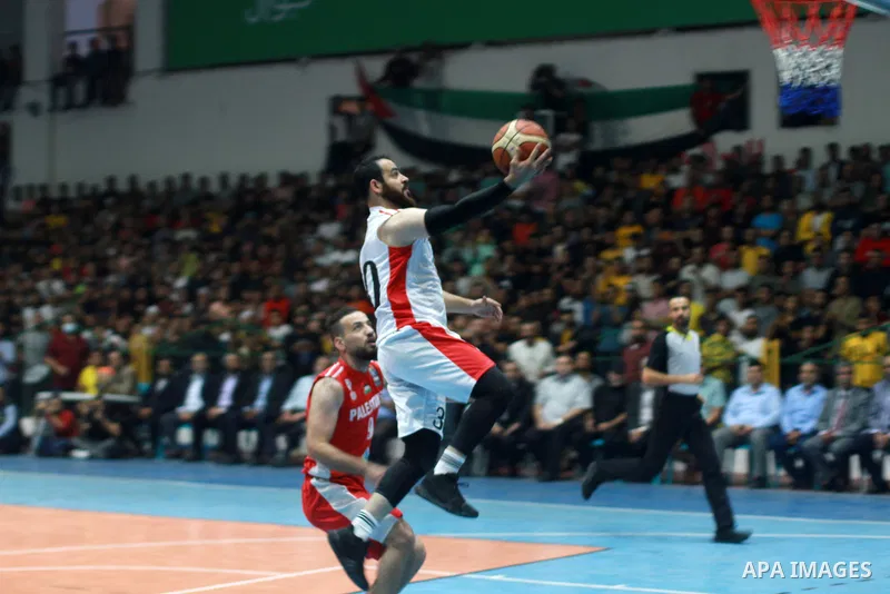 Palestinian players from Khadamat al-Maghazi club (Red) and players from Khadamat Bureij club (White) fight during Basketball League Final, in Gaza city on November 3, 2021. Khadamat al-Maghazi club won 73-67. Photo by A...
