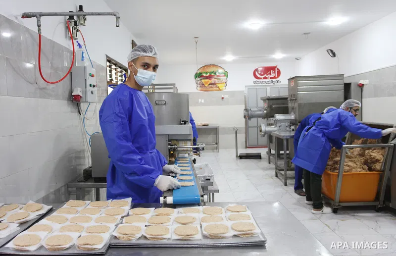 Palestinian workers prepare the chicken burger at atyab factory in Gaza City on 07 November. The first factory to manufacture chicken burgers in the Gaza Strip to meet the local market. Chicken burger is a proud supporte...