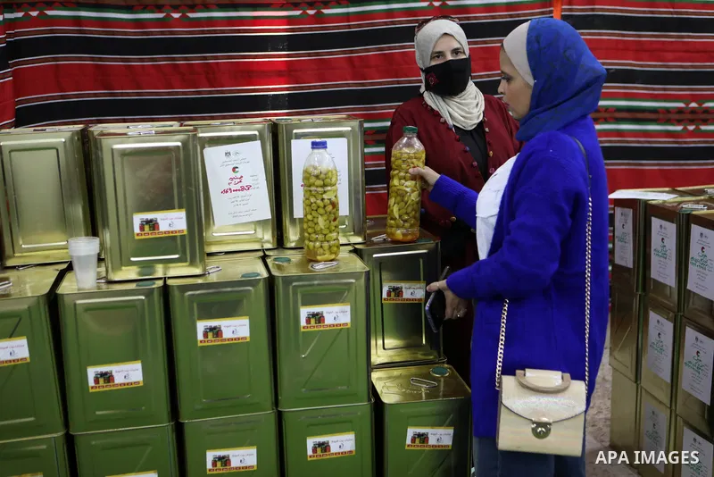 Palestinians participate in an exhibition of olive products and olive oil in the old city of Hebron, in the West Bank on November 10, 2021. Photo by Mamoun Wazwaz