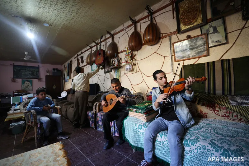 Palestinian Musician Khader al-Bayed gives music lessons on string instruments to youth and children at his home in Gaza city on November 10, 2021. Photo by Osama Baba