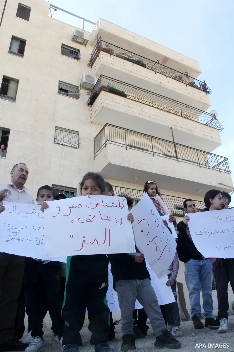 Palestinian residents of a house that is planned to be demolished by Israel, on grounds that it was built without a construction permit, demonstrate outside the building in the mostly-Arab east Jerusalem neighbourhood of...