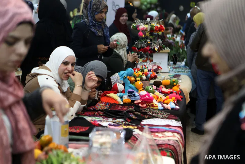 Palestinians attend an exhibition of women's handicrafts, in the West Bank city of Hebron, on November 14, 2021. The exhibition aims to market women's handicrafts to encourage women to develop themselves through their sm...