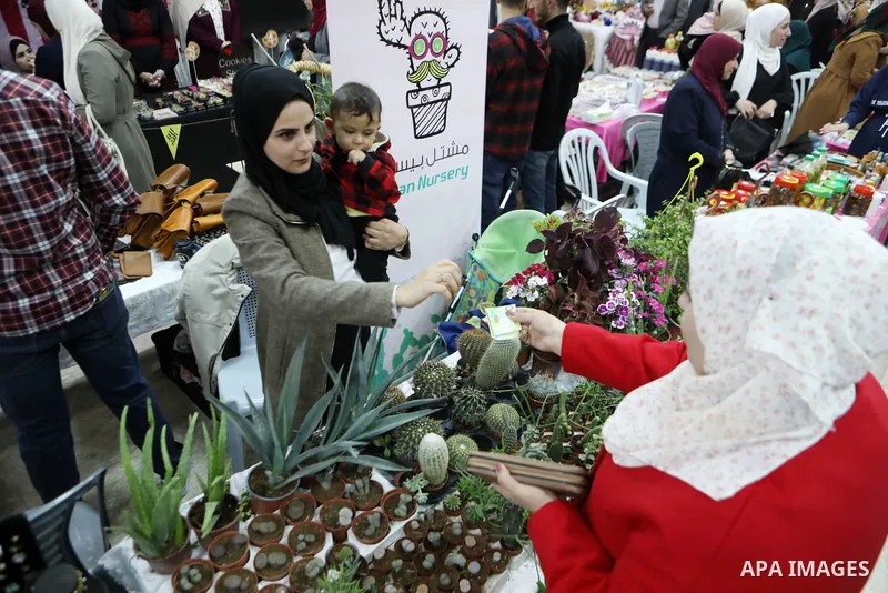 Palestinians attend an exhibition of women's handicrafts, in the West Bank city of Hebron, on November 14, 2021. The exhibition aims to market women's handicrafts to encourage women to develop themselves through their sm...