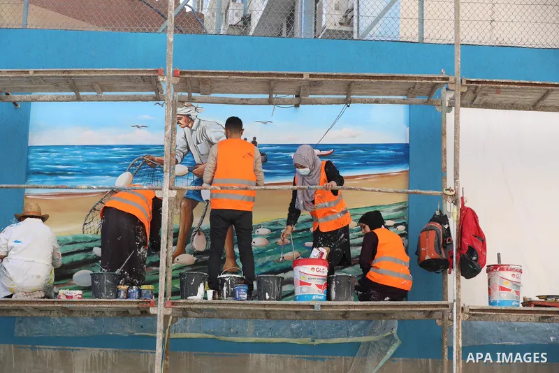 Palestinian artists paint murals in Gaza City on November 16, 2021. Several donor countries are scheduled to convene on Today in the Belgium capital Brussels under the auspices of Jordan and Sweden to discuss resuming th...