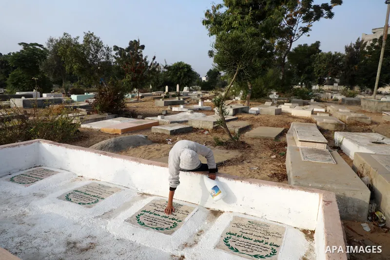 Palestinians clean the grave of the three daughters and niece of Palestinian doctor Izzeldin Abuelaish, who were killed in a direct missile hit on their Gaza home in the 2009 war between Israel and Hamas, in town of Beit...