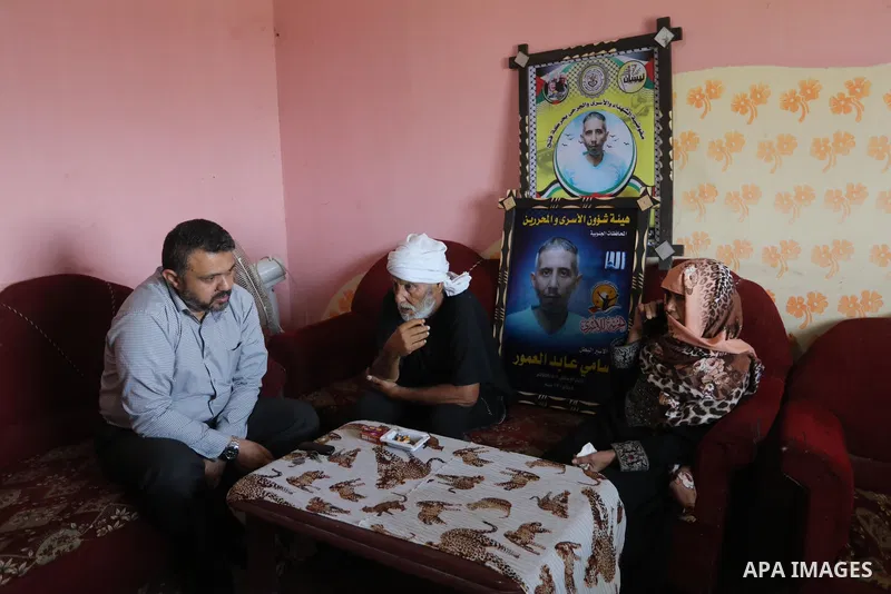 The family of the Palestinian prisoner, Sami Al-Amour sit at their home, in Deir al-Balah camp in the central Gaza Strip, on November 18, 2021. The al-Amour, 39, from the city of Deir al-Balah in the Gaza Strip, died in...