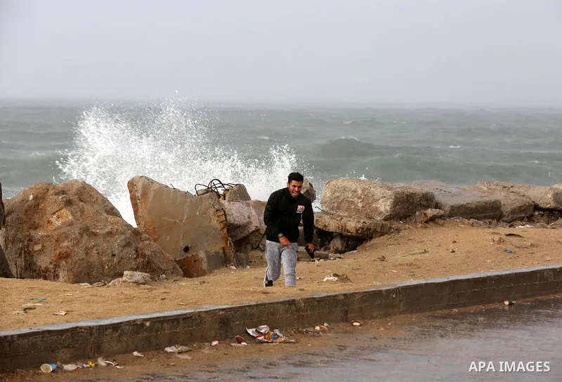 Palestians enjoy during a rainy day, at a beach in Gaza City 20 November 2021. A low pressure front is expected to affect Palestine today causing temperature to plummet and approach 7°C below the seasonal average and pav...