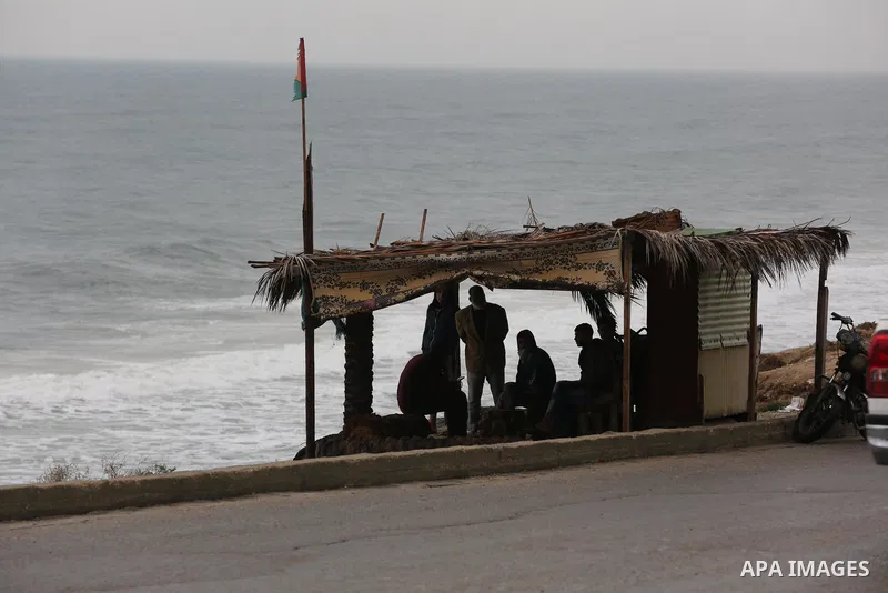 Palestinians show as they in their daily lives during a rainy day, in Deir al-Balah in the center of Gaza strip on November 21, 2021. The effects of the low pressure front which affected Palestine yesterday are expected...