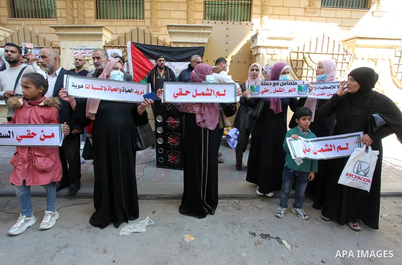 Palestinians hold IDs and banners to demand of the family reunification in front of the headquarter United Nation "UNSCO" in Gaza city, on 22 November 2021. Thousands of Palestinians have suffered as a result of the law,...