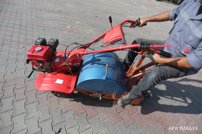 Palestinian engineers invent a street sweeping machine, in Deir al-Balah, in the center of Gaza strip, on November 25, 2021. Engineers invented a machine for sweeping and cleaning streets to facilitate the work of cleane...