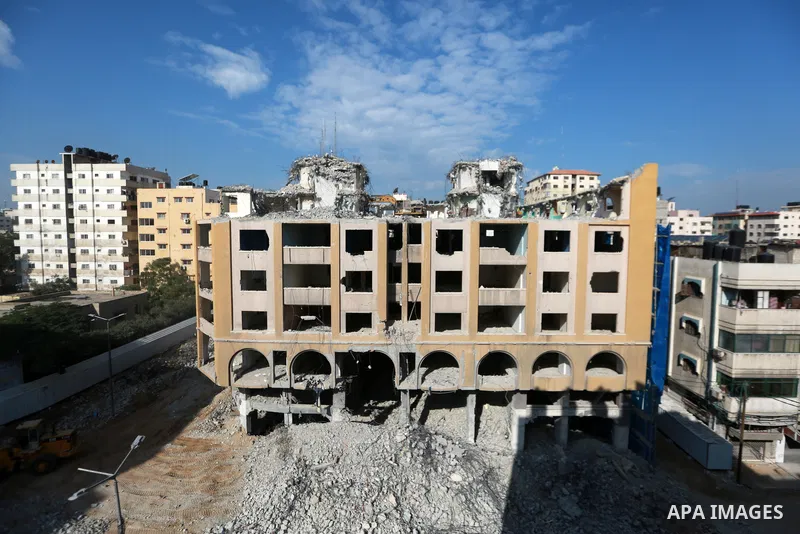 Palestinian workers remove the rubbles of al-Jawhara tower which was hit by Israeli strikes during the recent 11-day conflict between Israel and Hamas on May, in Gaza city on November 25, 2021. Photo by Bashar Taleb