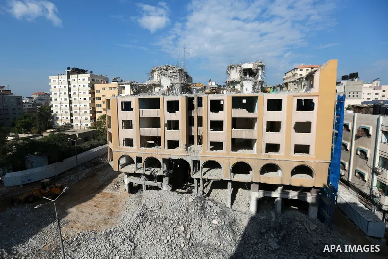 Palestinian workers remove the rubbles of al-Jawhara tower which was hit by Israeli strikes during the recent 11-day conflict between Israel and Hamas on May, in Gaza city on November 25, 2021. Photo by Bashar Taleb