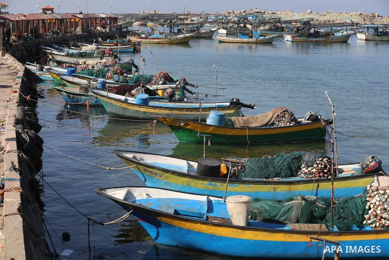 Palestinian fishermen work on the shore of the Mediterranean Sea, in Gaza city, on November 27, 2021. The Israeli authorities released the two detained fishermen at Erez crossing, north of Gaza, and seized their boat. Is...