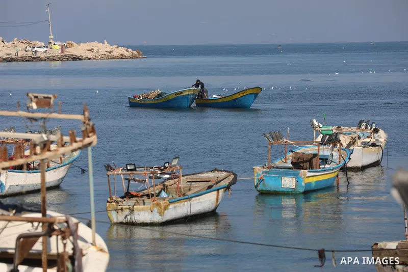 Palestinian fishermen work on the shore of the Mediterranean Sea, in Gaza city, on November 27, 2021. The Israeli authorities released the two detained fishermen at Erez crossing, north of Gaza, and seized their boat. Is...