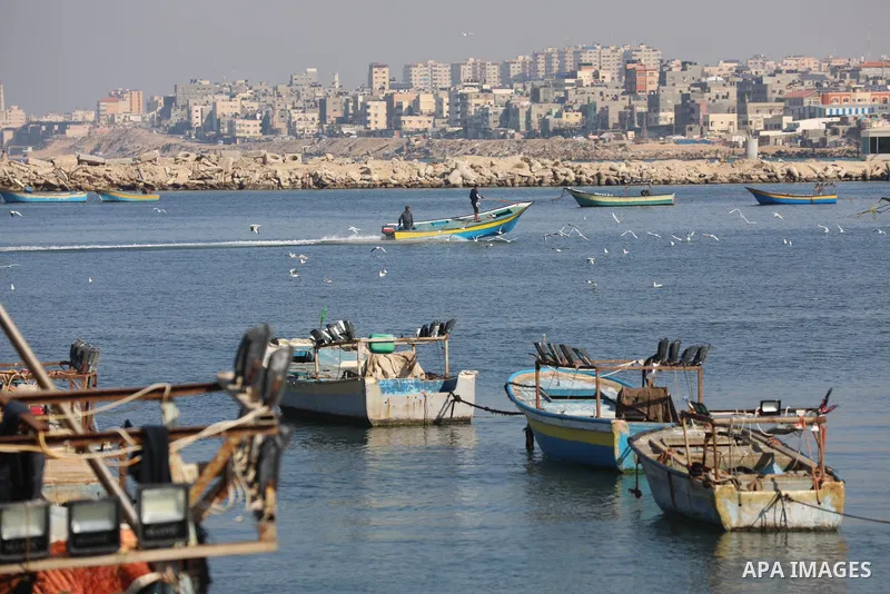 Palestinian fishermen work on the shore of the Mediterranean Sea, in Gaza city, on November 27, 2021. The Israeli authorities released the two detained fishermen at Erez crossing, north of Gaza, and seized their boat. Is...