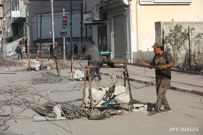 Palestinian workers remove the rubbles of al-Jawhara tower which was hit by Israeli strikes during the recent 11-day conflict between Israel and Hamas on May, in Gaza city on November 25, 2021. People and businesses in t...