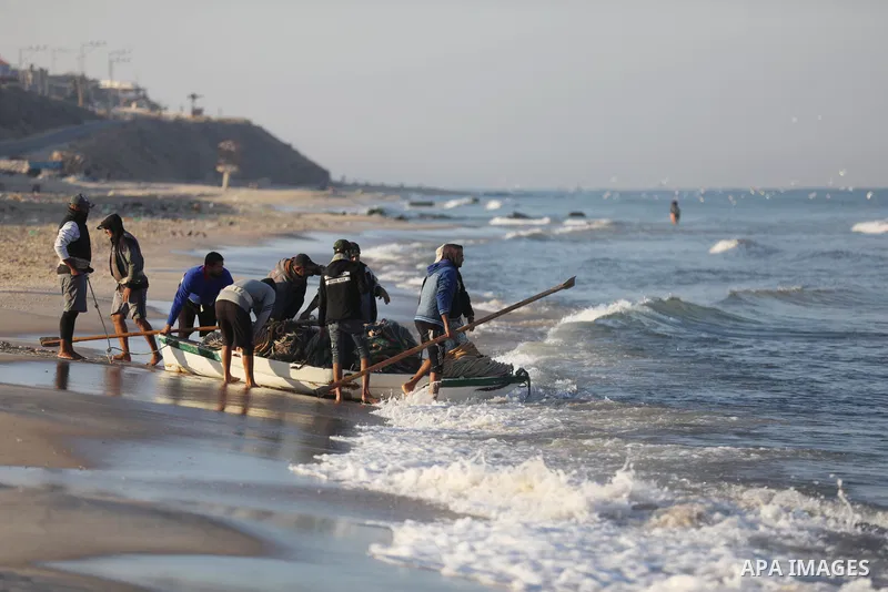 Palestinian fishermen work on the shore of the Mediterranean Sea, in Gaza city, on November 27, 2021. The Israeli authorities released the two detained fishermen at Erez crossing, north of Gaza, and seized their boat. Is...