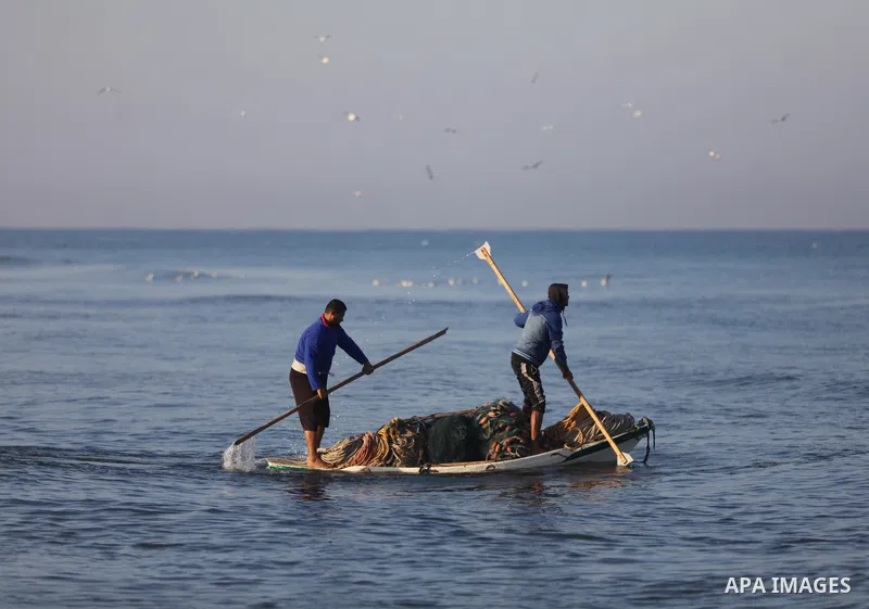 Palestinian fishermen work on the shore of the Mediterranean Sea, in Gaza city, on November 27, 2021. The Israeli authorities released the two detained fishermen at Erez crossing, north of Gaza, and seized their boat. Is...