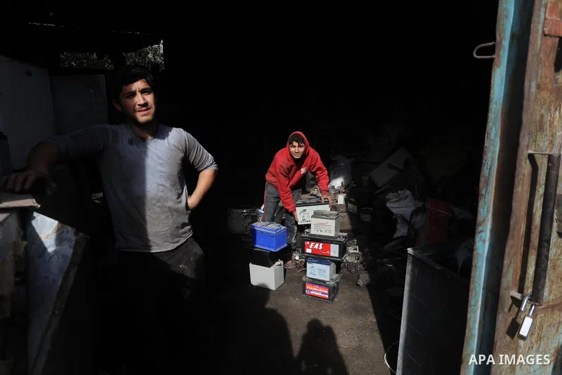 A Palestinian worker sorts through electronic waste such as batteries, a popular product in the midst of Gaza’s electricity crisis, after Israeli authorities prevented the export of 25,000 tons of damaged batteries, in J...