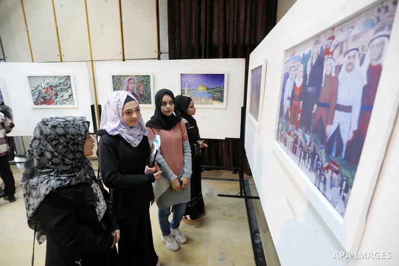 Palestinians attend the international art exhibition "Palestine in the eyes of Russia" on the International Day of Solidarity with the Palestinian People, in Gaza city on November 29, 2021. Photo by Ashraf Amra
