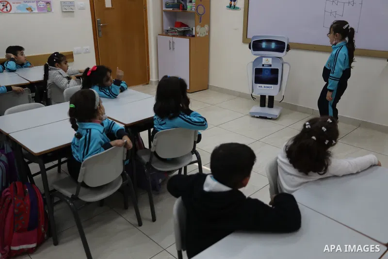 Palestinian students interact with a locally-made educational robot during a science class at a private school in Gaza City on November 30, 2021. Photo by Ashraf Amra