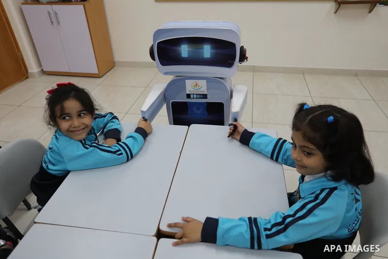 Palestinian students interact with a locally-made educational robot during a science class at a private school in Gaza City on November 30, 2021. Photo by Ashraf Amra