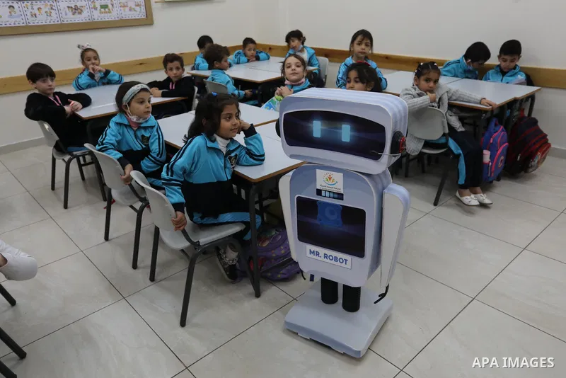 Palestinian students interact with a locally-made educational robot during a science class at a private school in Gaza City on November 30, 2021. Photo by Ashraf Amra