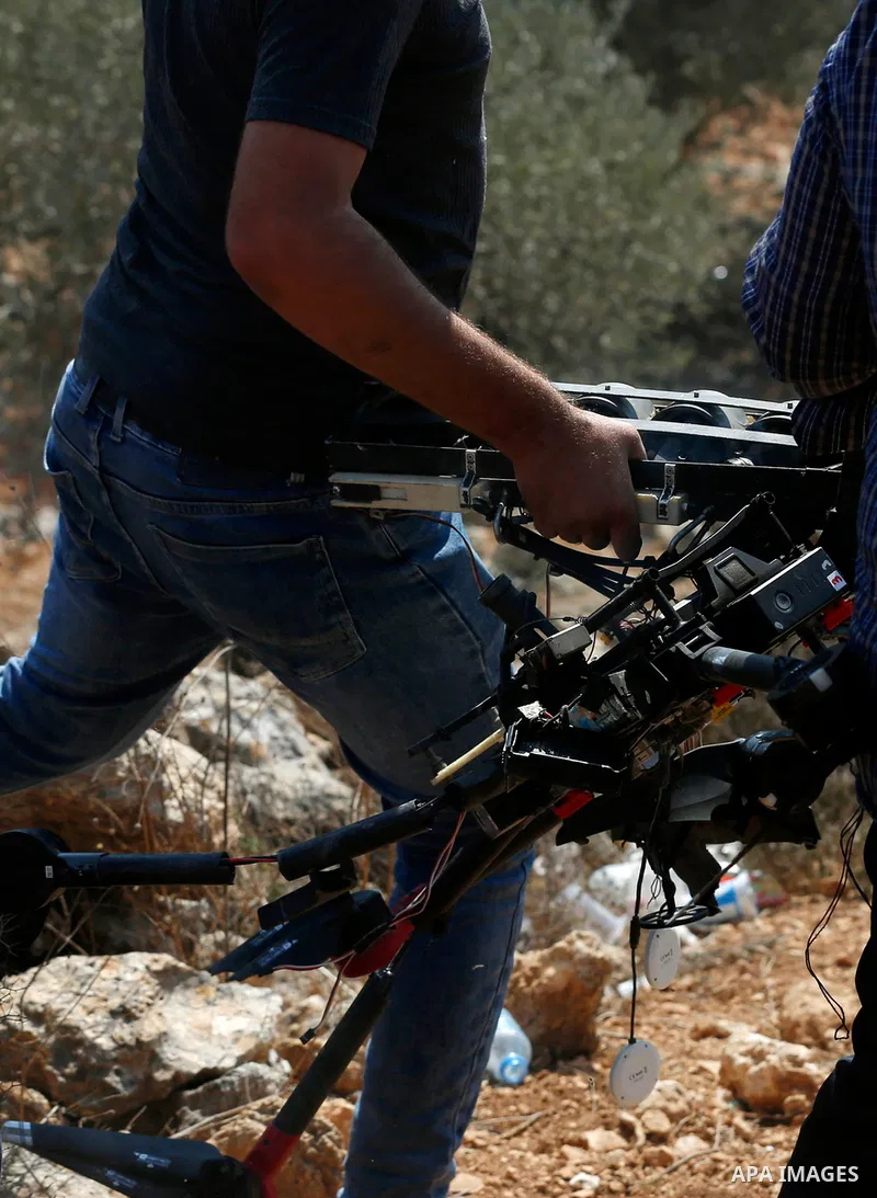 Palestinian protesters smash an Israeli drone that reportedly fell because of a technical failure, during a demonstration against settlements in the West Bank village of Beita, near Nablus on October 1, 2021. Photo by St...