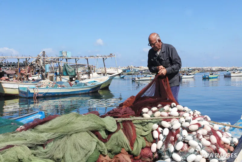 Palestinian fisherman, Rashad Al-Hassi, 77, works on his fishing net, at Gaza seaport, on October 2, 2021. The International Day of Older Persons is observed on October 1 each year. Being a fisherman in Gaza means to pra...