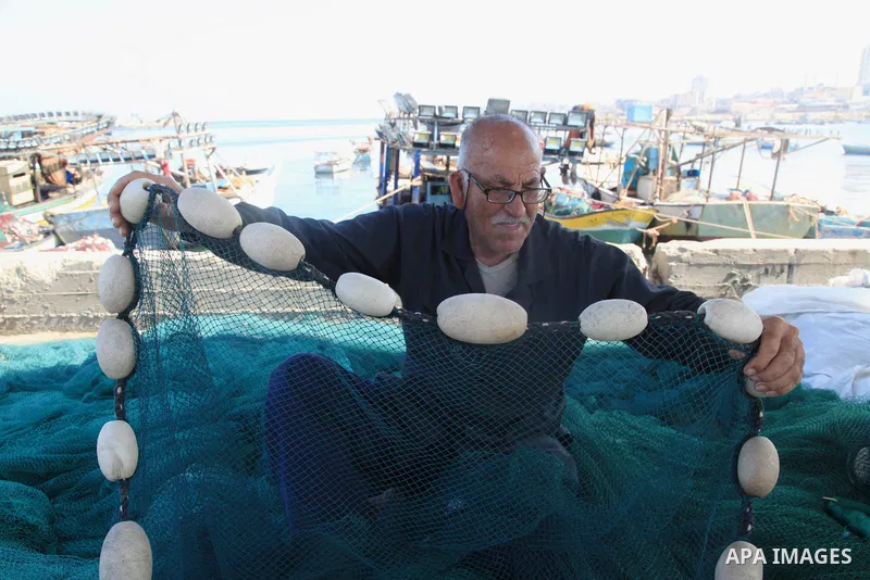 Palestinian fisherman, Rashad Al-Hassi, 77, works on his fishing net, at Gaza seaport, on October 2, 2021. The International Day of Older Persons is observed on October 1 each year. Being a fisherman in Gaza means to pra...