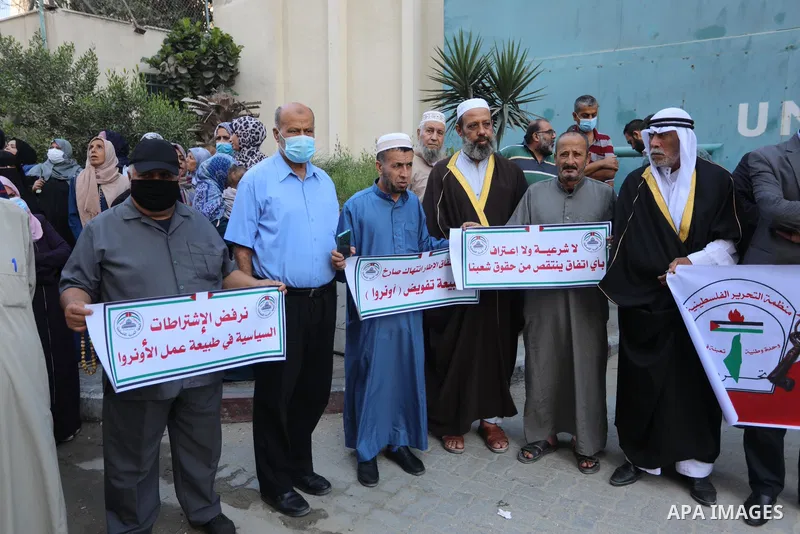 Palestinians take part in a protest against the United States and UNRWA signing a Framework for Cooperation in front of the headquarters United Nations Relief and Works Agency (UNRWA), in Gaza city on October 05, 2021. T...