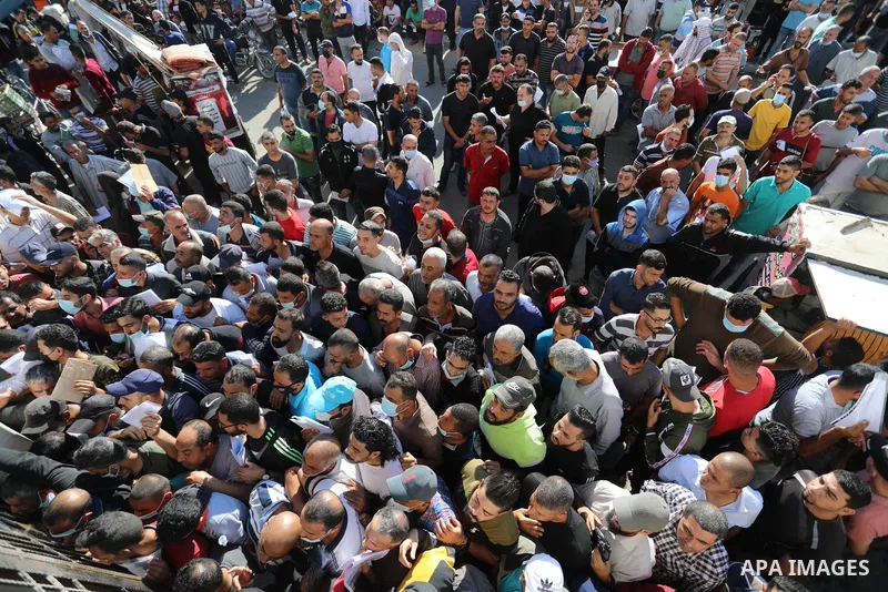 Palestinian citizens gather to apply for work permits in Israel territories in front of the Gaza Chamber of Commerce and Industry ​headquarters to register in order to work inside the Israel territories, in Deir al-Balah...