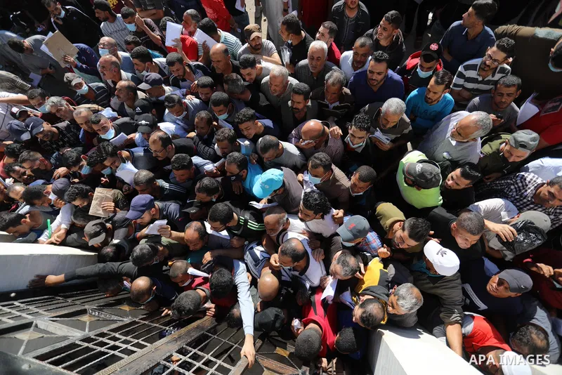 Palestinian citizens gather to apply for work permits in Israel territories in front of the Gaza Chamber of Commerce and Industry ​headquarters to register in order to work inside the Israel territories, in Deir al-Balah...