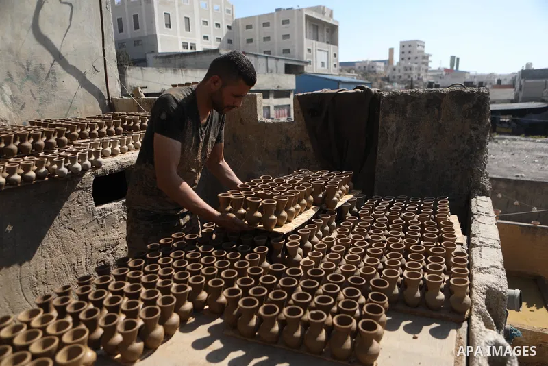 A Palestinian pottery worker makes earthenware vases at a pottery workshop in the West Bank city of Hebron on 07 October 2021. Pottery is a very ancient and traditional industry in Hebron. It has been known since more th...
