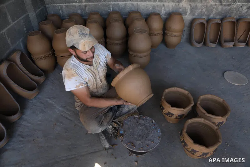 A Palestinian pottery worker makes earthenware vases at a pottery workshop in the West Bank city of Hebron on 07 October 2021. Pottery is a very ancient and traditional industry in Hebron. It has been known since more th...